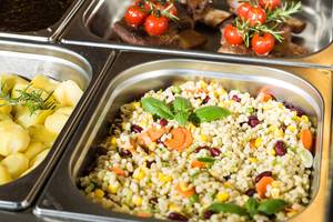 Ansicht vom Mittagsbuffet mit Reis, Kartoffeln und Tomaten